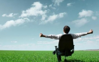 Man sitting on a chair outside an open field
